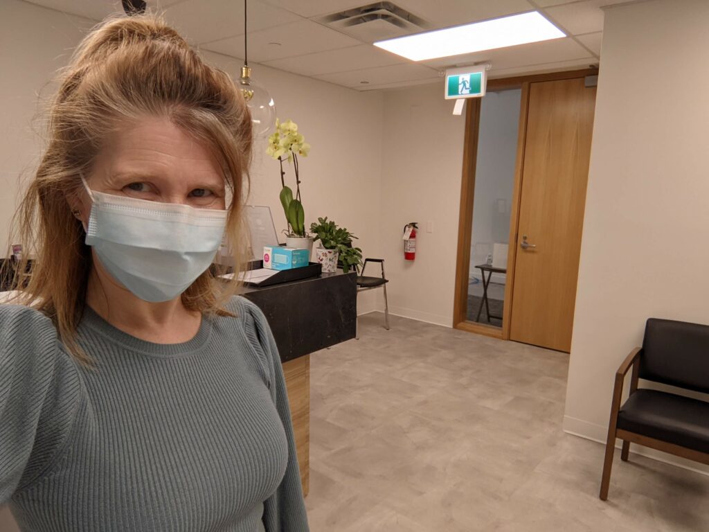Photo of rheumatoid arthritis patient JG Chayko in the doctor's office where she works as a frontline worker during the COVID pandemic